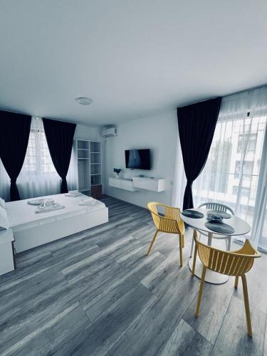 a living room with a bed and a table and chairs at Sea Panorama Apartments & Free Parking in Năvodari