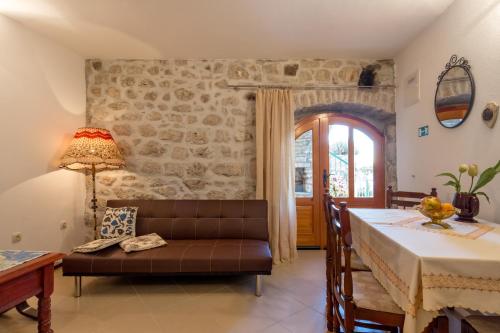 un soggiorno con un tavolo e un divano di Renovated Old Stone House a Lokva Rogoznica