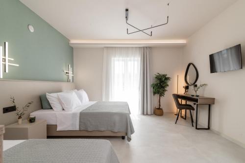a bedroom with a bed and a desk and a clock at Hera Zakynthos Hotel in Laganas