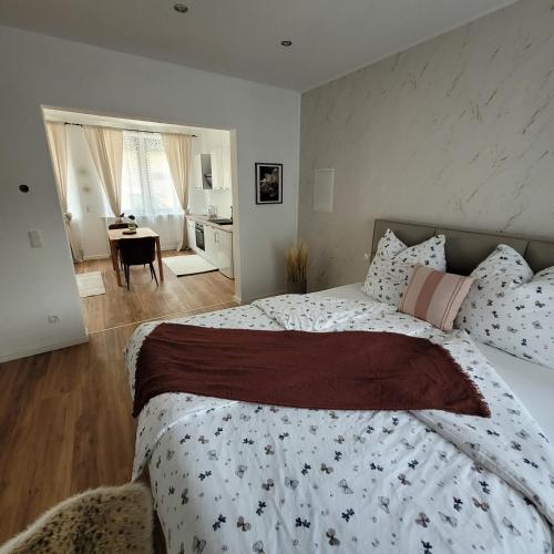 a bedroom with a large bed and a dining room at Ferienwohnungen Ahrweiler in Bad Neuenahr-Ahrweiler