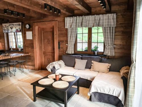 a living room with a couch and a table at Domek pod skałą in Krościenko