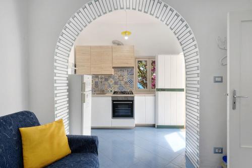 an archway in a kitchen with a blue couch at Blueandgreen Apartment Amalfi Coast in Maiori