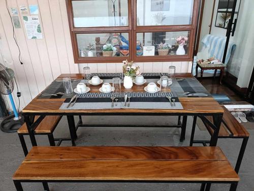 a wooden table with plates and dishes on it at MyGuide Travellers Inn in Coron