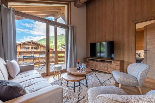 un salon avec un canapé et une télévision dans l'établissement Megève appartement 4 pièces résidence de standing, à Megève