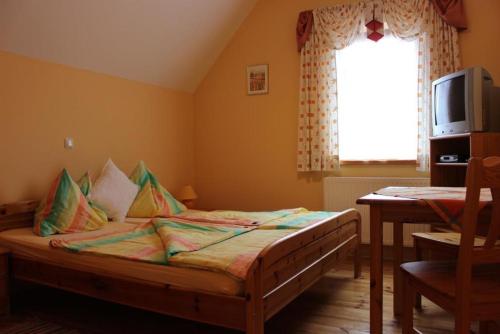 a bedroom with a bed and a table and a window at Weingut Juritsch in Leutschach