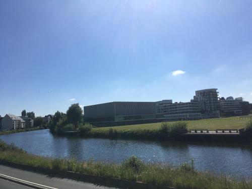 a river in the middle of a city with buildings at La chambre de Mathilde in Caen