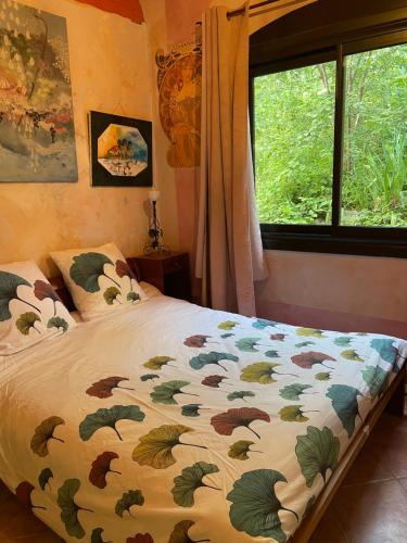 a bedroom with a bed with a comforter and a window at DOMAINE St GEORGES in Mosset