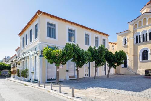 a building with trees in front of a street at Agora Suites in Athens