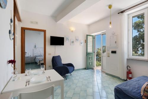 a room with a bed and a table and a tv at Blueandgreen Apartment Amalfi Coast in Maiori