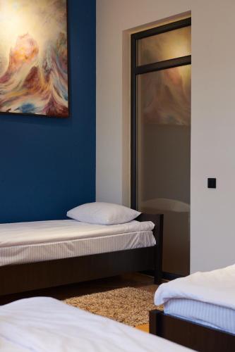 a room with two beds and a painting on the wall at Lama Hostel in Ivano-Frankivsʼk