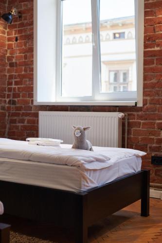 a stuffed lamb sitting on top of a bed at Lama Hostel in Ivano-Frankivsʼk
