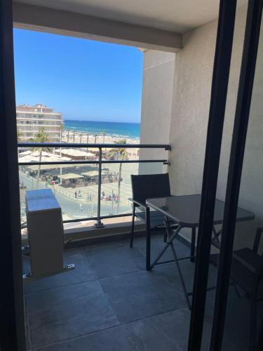 Un balcón con mesa y vista a la playa. en Canet Studio, en Canet-en-Roussillon