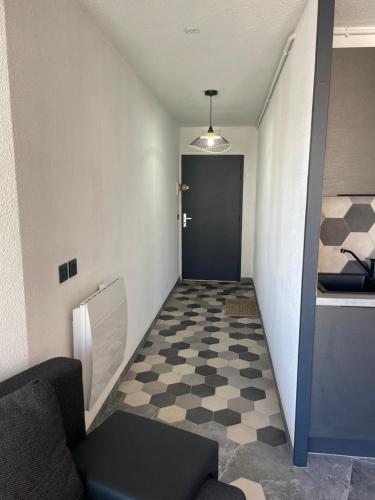 un couloir avec une porte et un sol en damier dans l'établissement Canet Studio, à Canet