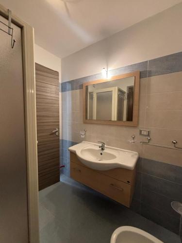 a bathroom with a sink and a mirror and a toilet at Fraicol in Santa Domenica