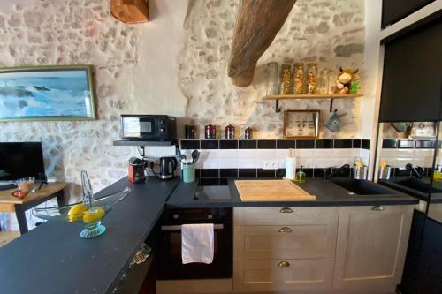 une cuisine avec un évier et un plan de travail dans l'établissement La Sanverine beautiful renovated apartment with terrace, à Vence