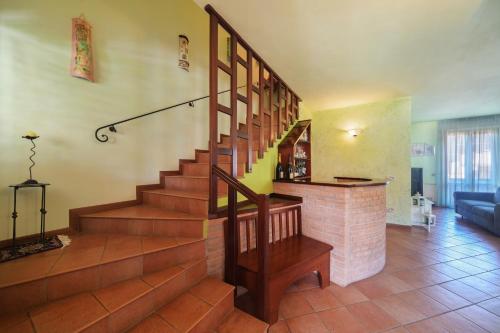 a living room with a staircase and a brick fireplace at Casa Lorenzo in Spello