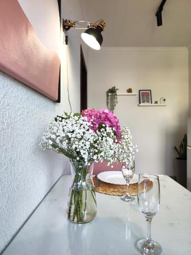 a vase of flowers sitting on a table with two glasses at Best One Room Apartments in Mukacheve