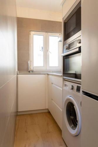 a kitchen with a washing machine and a window at Loft con amplia terraza en el centro de Santander in Santander