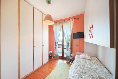 a bedroom with orange walls and a bed and a mirror at Casa Lorenzo in Spello