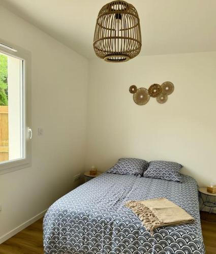 une chambre avec un lit avec une couette bleue et une fenêtre dans l'établissement Villa à deux pas du Lac, à Léon