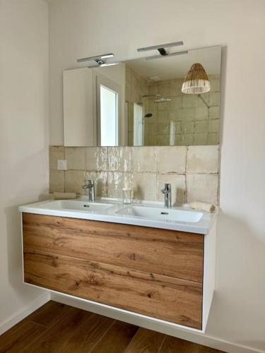 une salle de bain avec un lavabo et un miroir dans l'établissement Villa à deux pas du Lac, à Léon