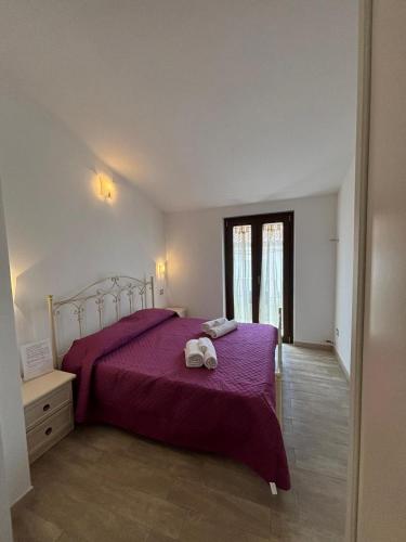 a bedroom with a purple bed with two towels on it at Fraicol in Santa Domenica