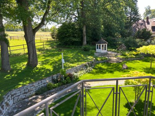 a garden with a stone fence and a gazebo at Herrenhaus - Starnberger See - Ammerland in Münsing am Starnberger See