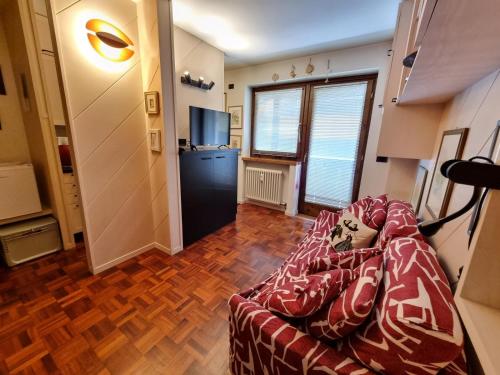 a living room with a couch and a television at Arnica in Canazei
