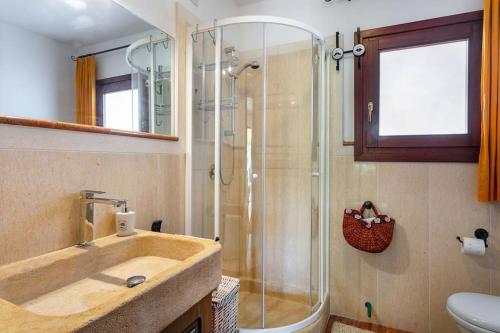 a bathroom with a glass shower and a sink at VILLA Piera SOS ARANZOS -Golfo Aranci Sea View- in Pittulongu