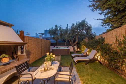 a backyard with a table and chairs and a fence at Olive Spa House in Aegina Town