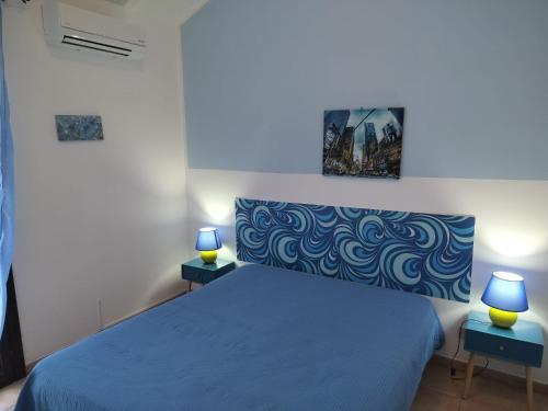 a bedroom with a blue bed with two lamps at RESIDENCE 3 STARs SAN VITO LO CAPO in San Vito lo Capo