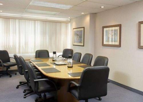 a conference room with a large wooden table and chairs at Quality Inn & Suites PE Trudeau Airport in Dorval