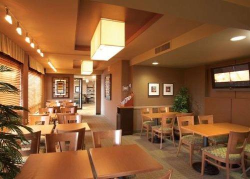 a restaurant with wooden tables and chairs in a room at Quality Inn & Suites PE Trudeau Airport in Dorval
