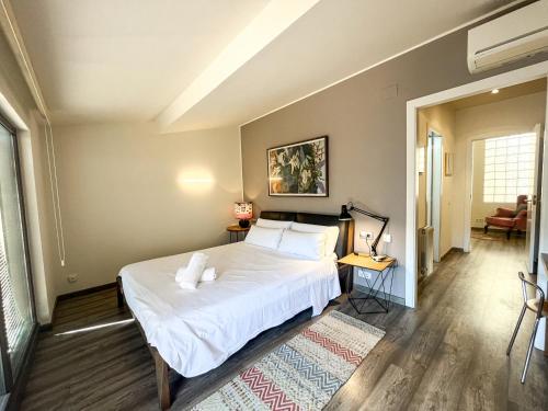un dormitorio con una cama con sábanas y almohadas blancas en Sleep & Stay- Luxury top floor apt with terrace, en Girona