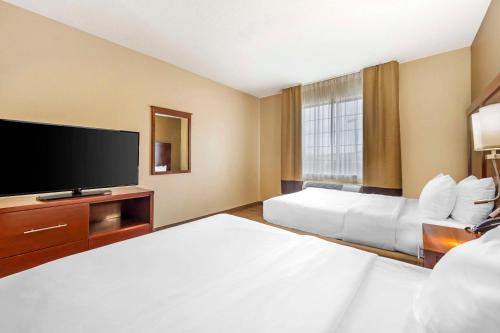 a hotel room with two beds and a flat screen tv at Comfort Suites in Castle Rock