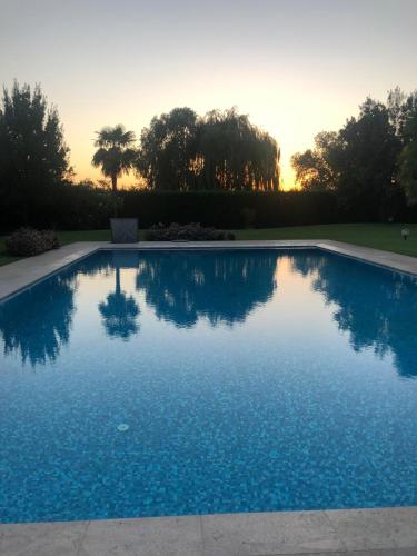 a swimming pool with a sunset in the background at VILLA SAVALIN in Taglio di Po