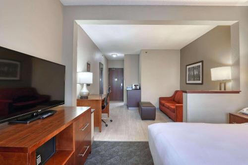 a hotel room with a bed and a flat screen tv at Comfort Suites Madison West - Middleton in Madison