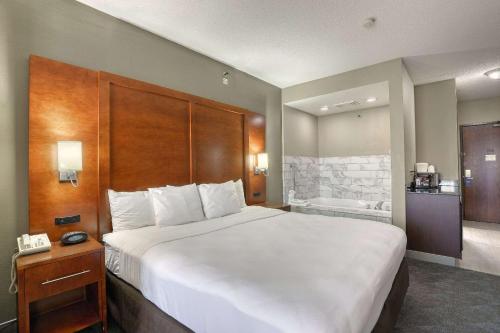 a hotel room with a large bed and a bathroom at Comfort Suites Madison West - Middleton in Madison