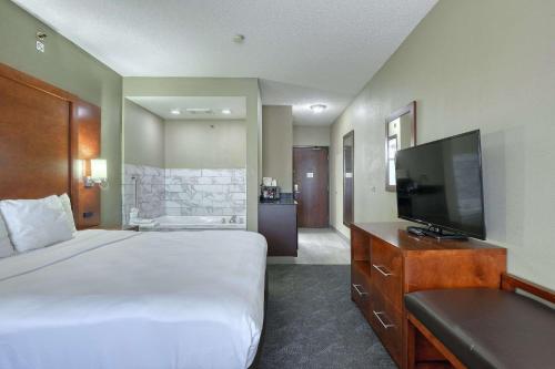a hotel room with a bed and a flat screen tv at Comfort Suites Madison West - Middleton in Madison
