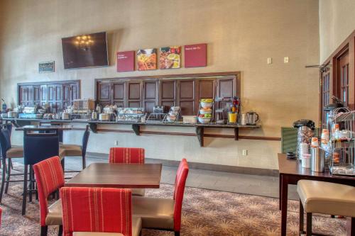 a restaurant with tables and chairs and a bar at Comfort Suites Madison West - Middleton in Madison
