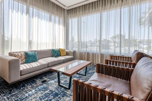 a living room with a couch and a table at Cambria Hotel Orlando Airport in Orlando