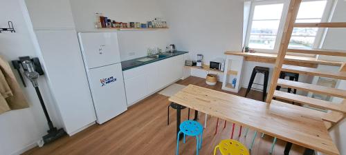 Il comprend une cuisine avec une table en bois et un réfrigérateur. dans l'établissement L'escale marine, à Calais