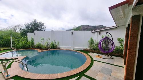 a swimming pool in the backyard of a house at Nostravila in Lonavala