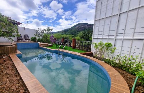 a swimming pool in front of a building at Nostravila in Lonavala