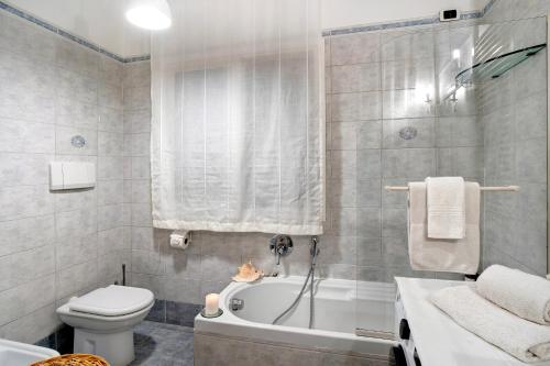 a bathroom with a tub and a toilet and a sink at Salice Felice in Ventimiglia