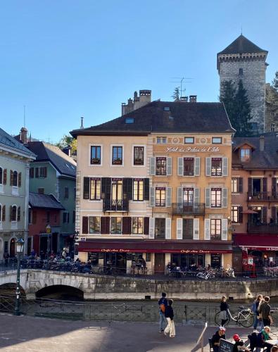 - un bâtiment à côté d'une rivière avec des gens qui y marchent dans l'établissement Le Rivage - Centre historique et Bord de lac, à Annecy