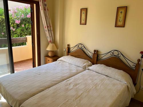 a bedroom with two beds and a sliding glass door at Espectacular casa Playas de Vera in Playas de Vera