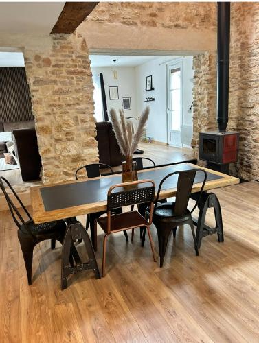 une salle à manger avec une table et des chaises et une cheminée dans l'établissement Le gîte du Château Mouton, à Châtenoy-le-Royal