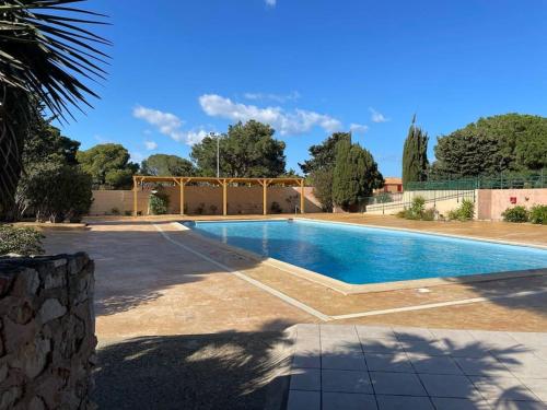 une grande piscine dans une cour avec une clôture dans l'établissement Appart 4pers - piscine - wifi - idéal famille, à Fitou