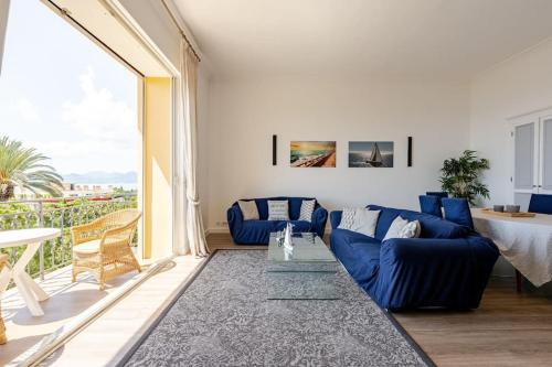 - un salon avec des canapés bleus et une grande fenêtre dans l'établissement NEWLY RENOVATED! Harbour View on Balcony Terrace, à Cannes